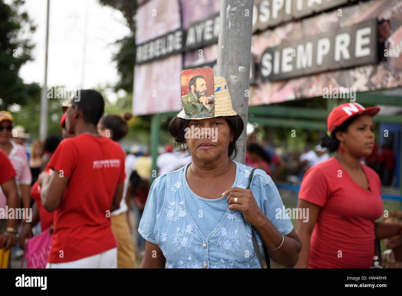 Cuban woman wearing a hat with Fidel Castro photograph attached during the May Day celebrations in Santiago De Cuba, Cuba. Stock Photo
