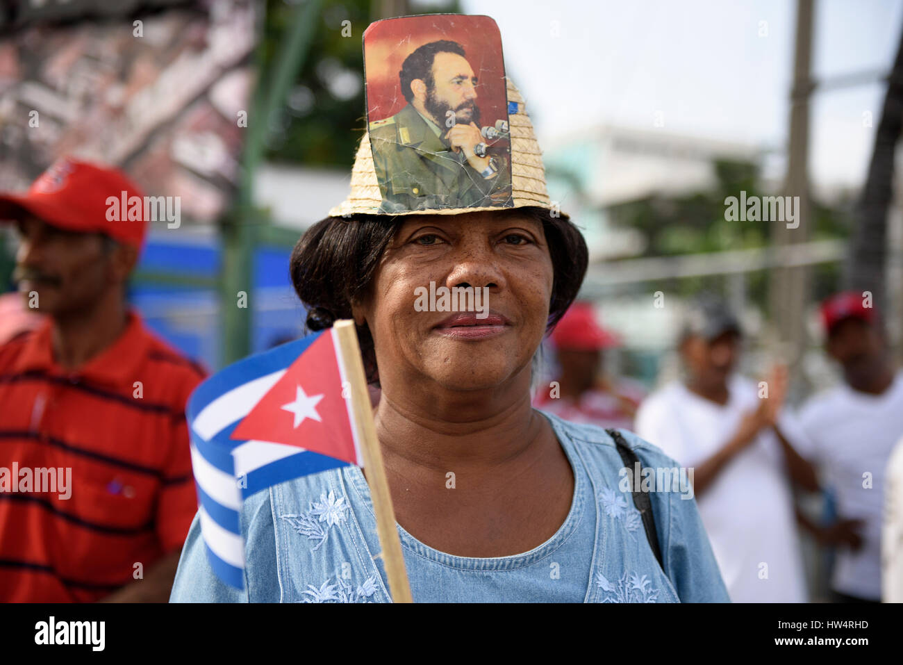 Cuban woman wearing a hat with Fidel Castro photograph attached during the May Day celebrations in Santiago De Cuba, Cuba. Stock Photo