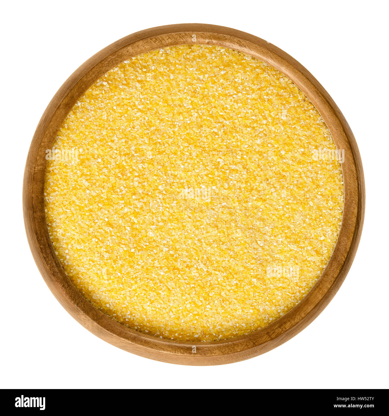Cornmeal in wooden bowl. Raw uncooked meal, medium ground from dried maize. Common stable food. Boiled cornmeal is called polenta. Stock Photo
