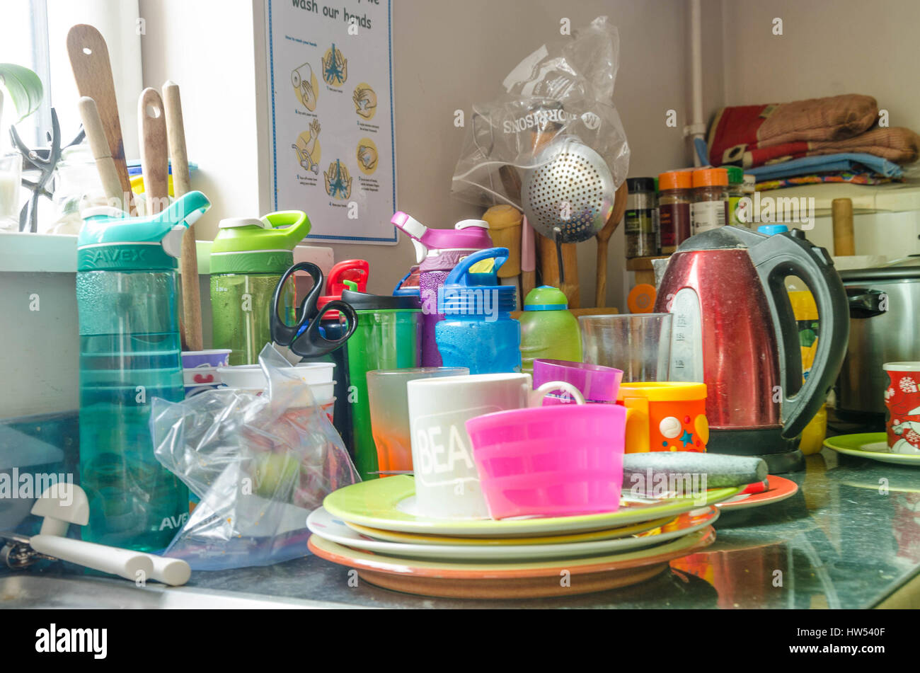 Washing up stacked at the side of a kitchen sink Stock Photo Alamy