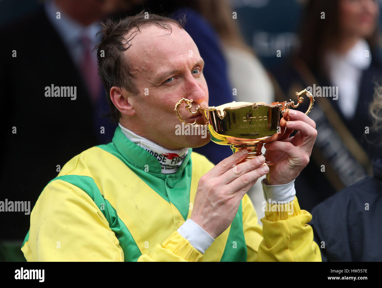 Jockey Robbie Power celebrates with the trophy after his winning ride on Sizing John in the Timico Cheltenham Gold Cup Chase during Gold Cup Day of the 2017 Cheltenham Festival at Cheltenham Racecourse. Stock Photo
