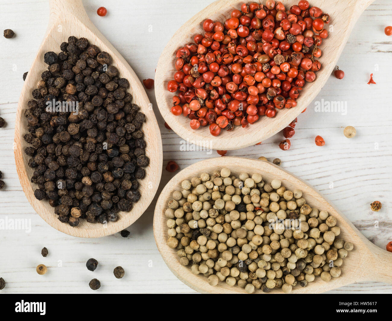 Whole Red White and Black Pepper Corns Against a White Background Stock Photo