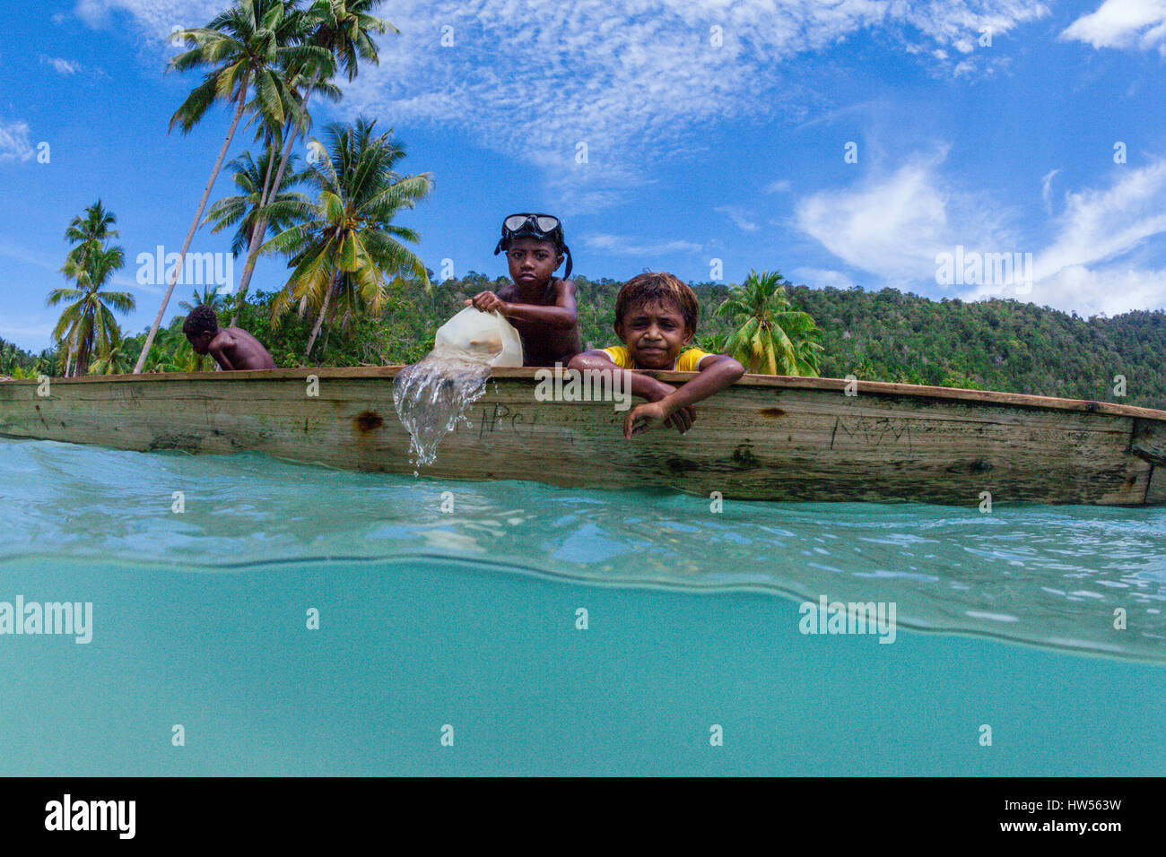 Kids in Canoe, Raja Ampat, West Papua, Indonesia Stock Photo