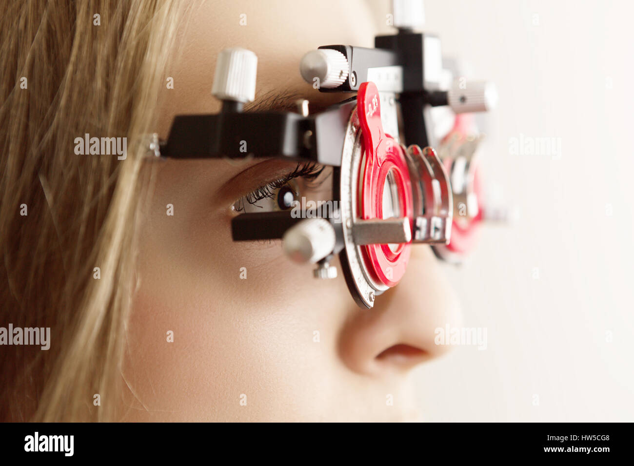 young woman during eyes examination with diagnostic frame in a optometric clinic, closeup Stock Photo