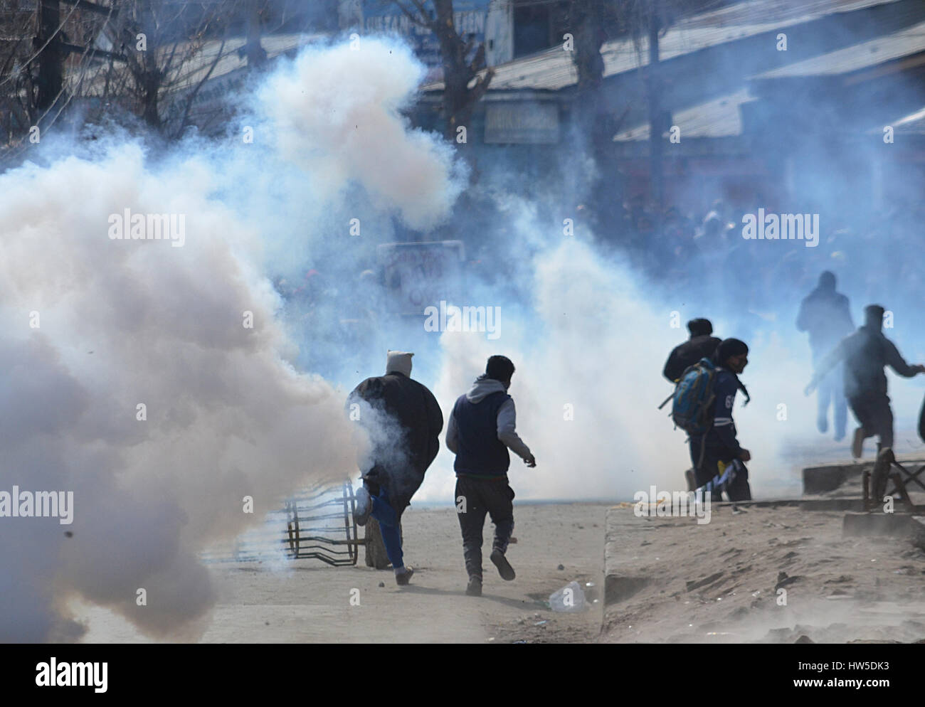 Kashmir, India. 17th Mar, 2017. Kashmiri Muslim protesters run as the tear gas canister fired by Indian police explodes in old Srinagar the summer capital of Indian controlled Kashmir. Protests and clashes erupt in old against the recent killings of civilians by Indian government forces in Kashmir. Earlier this week a 7 yr old girl was killed by government forces during a gun battle between militants and government forces north Kashmir's Kupwara. Credit: Faisal Khan/Pacific Press/Alamy Live News Stock Photo