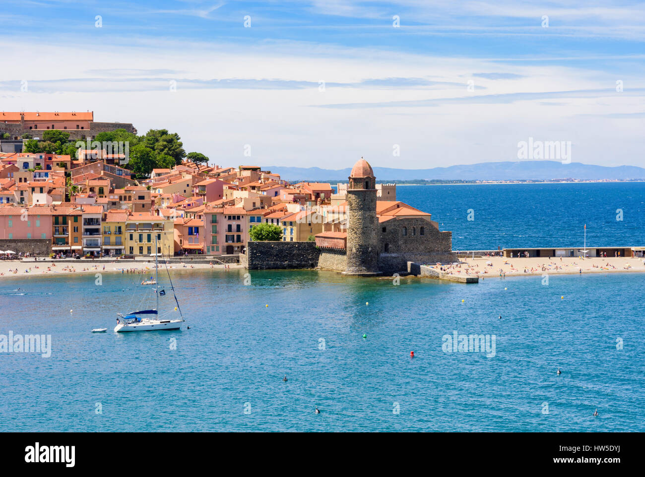 The old town and landmark bell tower of Notre Dame des Anges and yacht moored in the bay, Collioure, Côte Vermeille, France Stock Photo