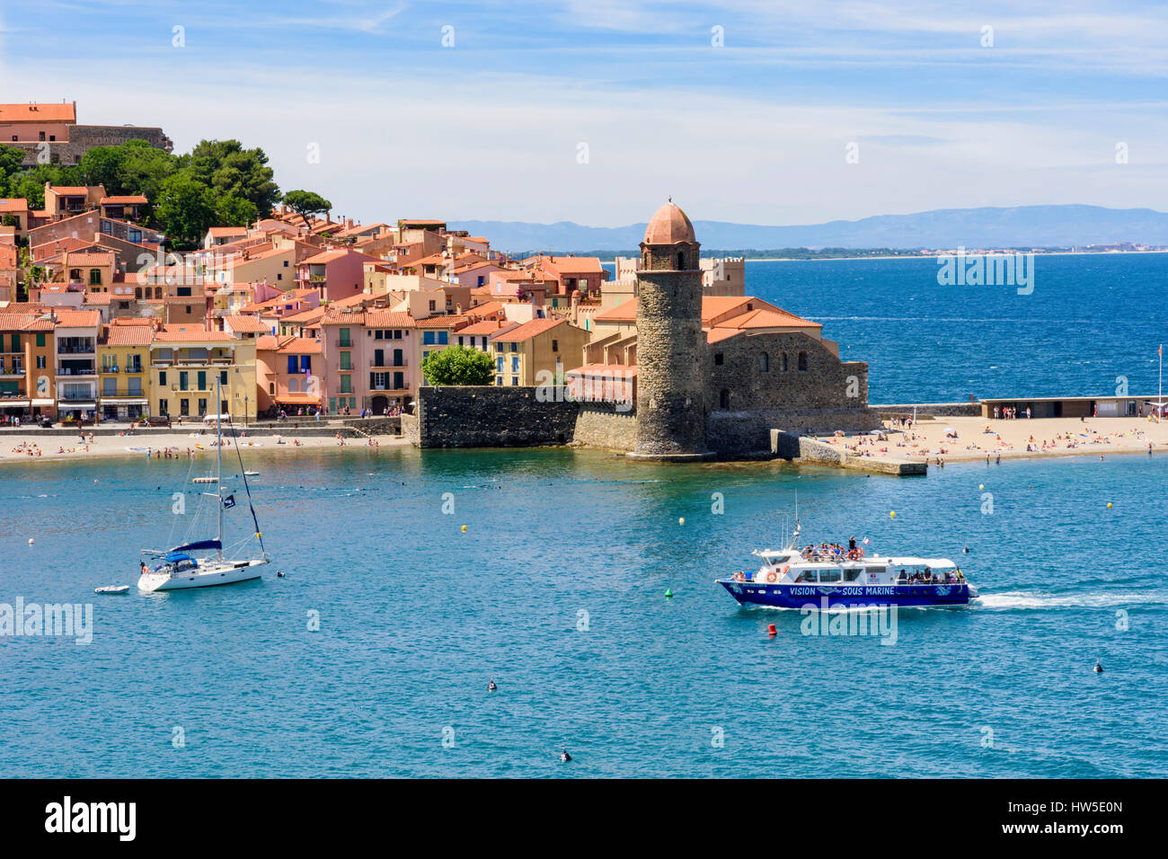 Tourist boat arrives in the old town of Collioure past the Notre Dame des Anges, Côte Vermeille, France Stock Photo