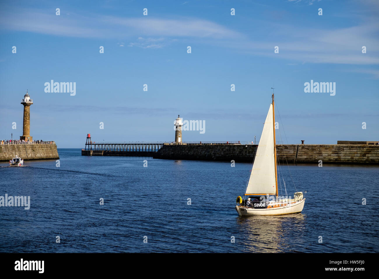 sailboat leaving Whitby Harbour, North Yorshire, United Kingdom Stock Photo