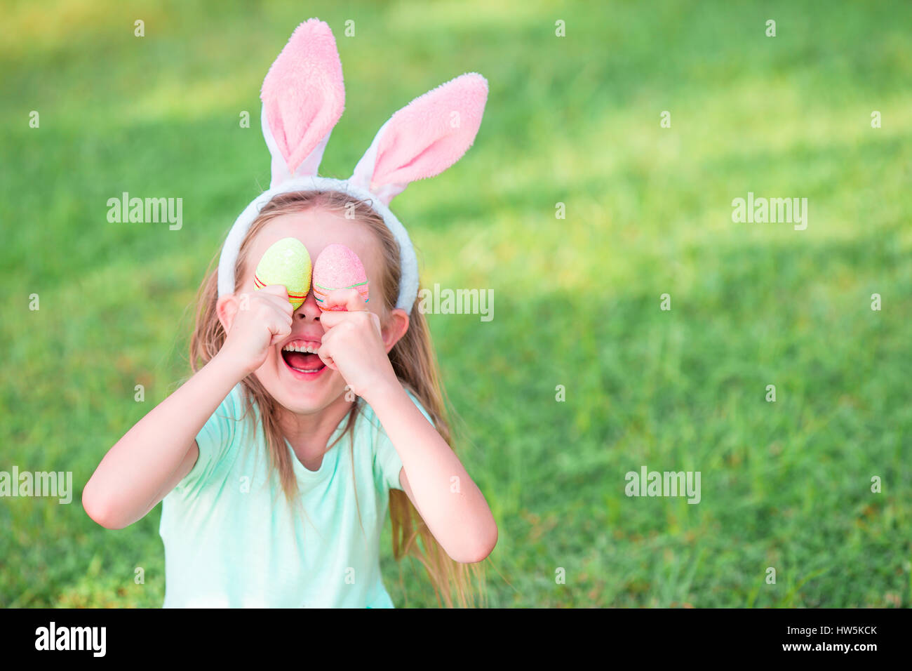 Adorable girl wearing bunny ears holding basket with Easter eggs Stock ...