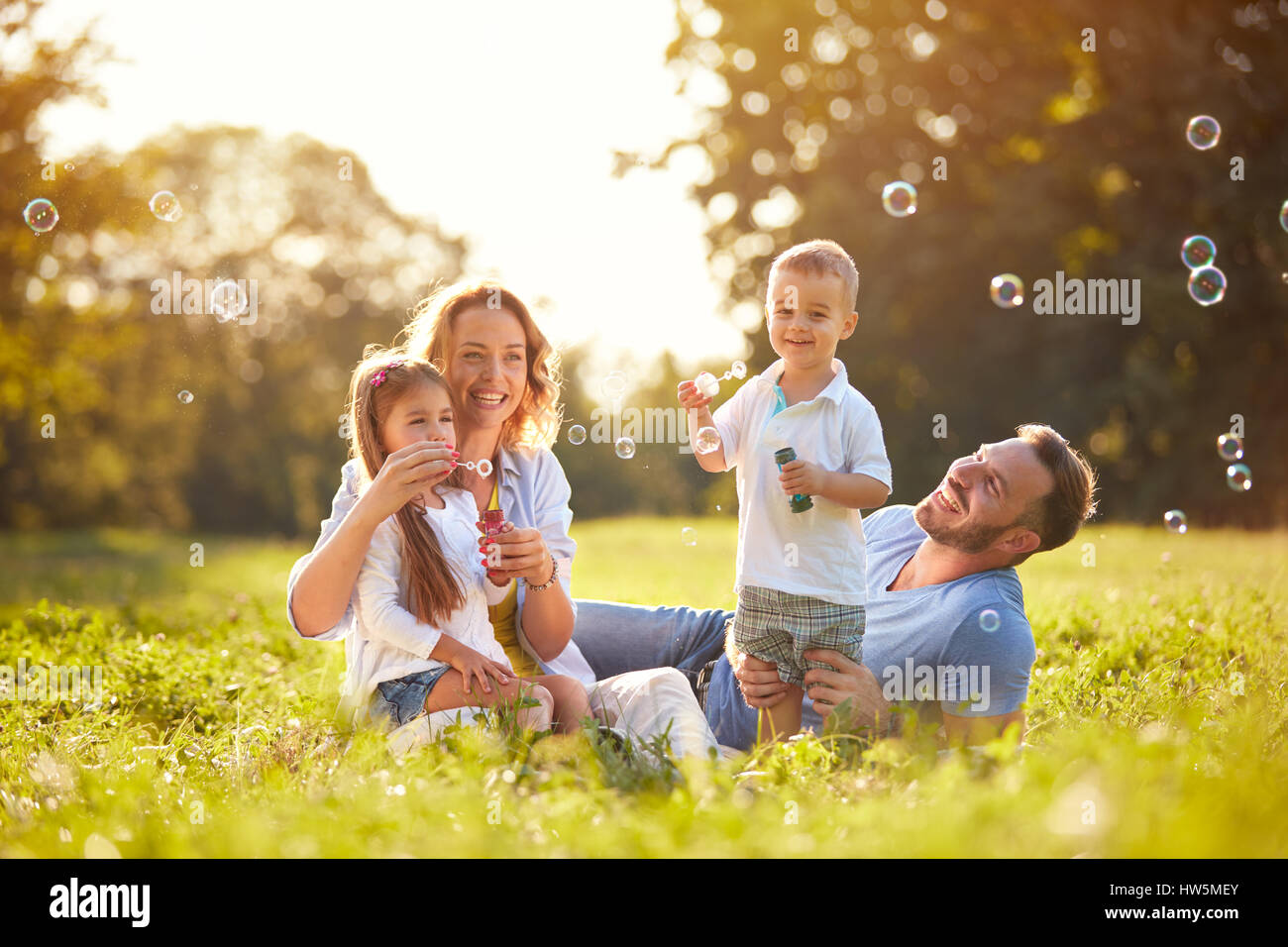 Family with children blow soap bubbles outdoor Stock Photo - Alamy