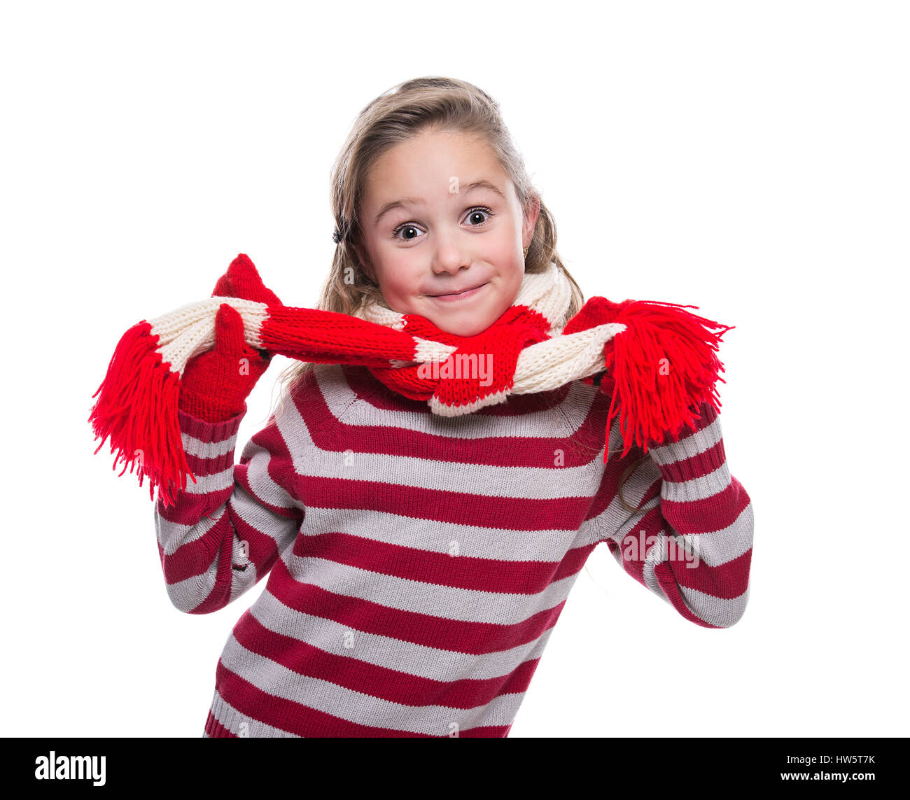 Cute cheerful little girl wearing striped knitted sweater, scarf and