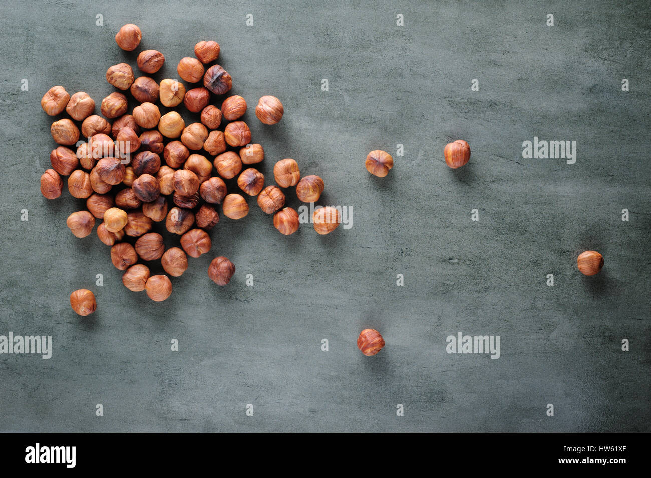 Peeled hazelnuts scattered over stone board Stock Photo