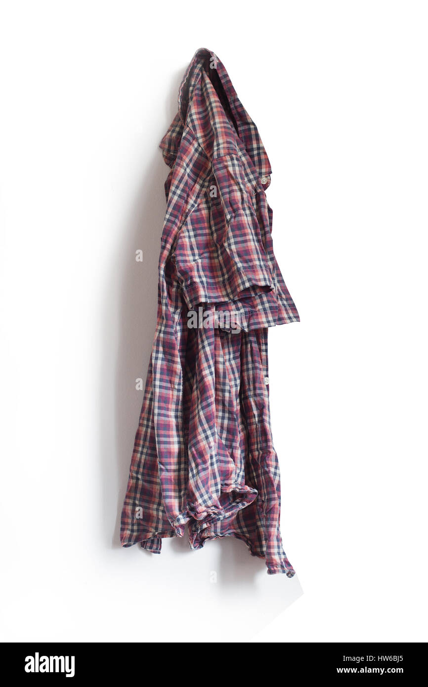 vertical front view of checkered shirt hanging on a white wall Stock Photo