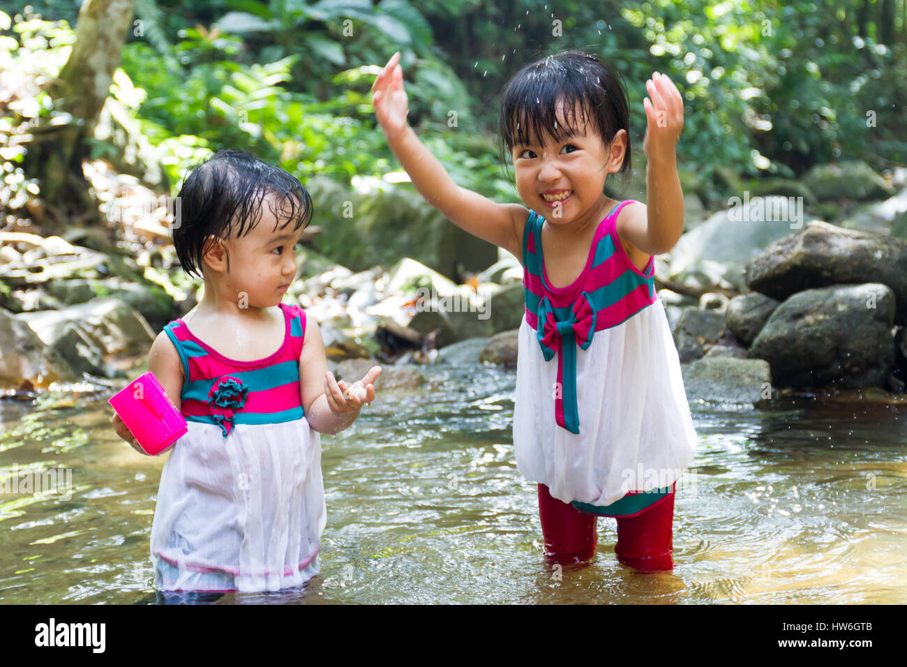 Asian Little Chinese Girls Playing in Creek in the Forest Stock Photo