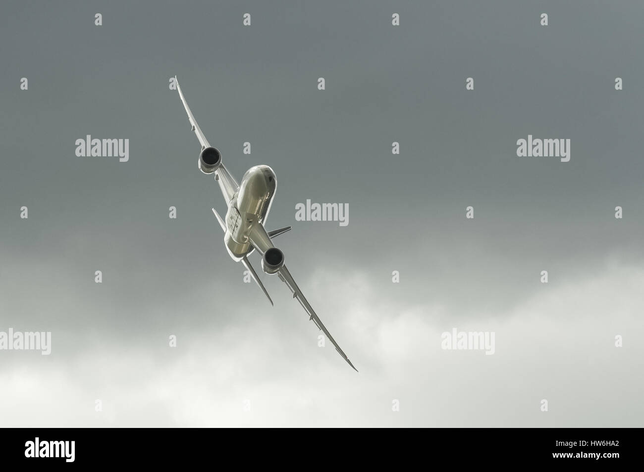 Boeing 787 Dreamliner in Qatar Airways livery banking steeply through dark clouds during a display at Farnborough Airshow, UK Stock Photo