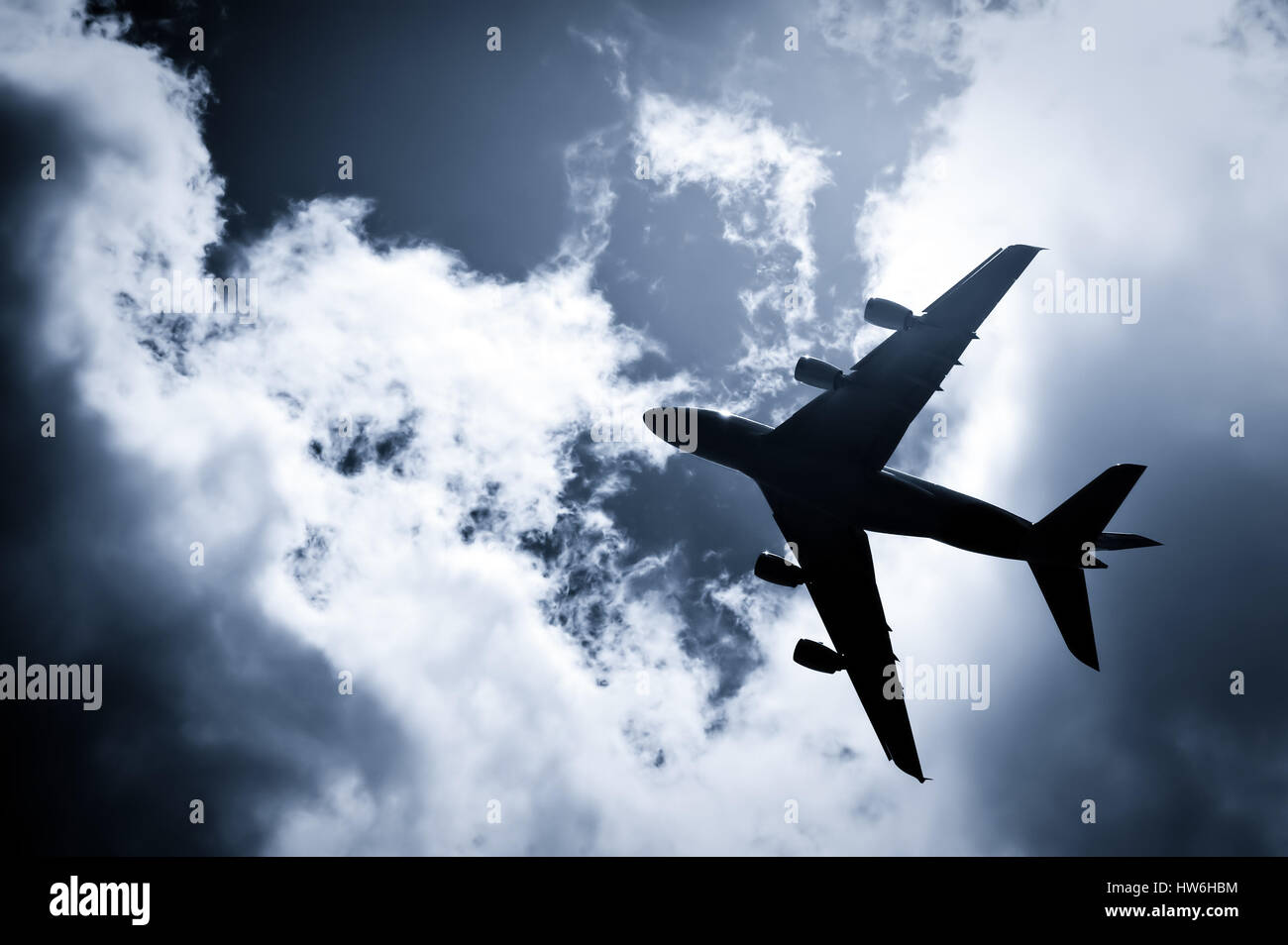 large passenger jet silhouette against a blue tinted sky Stock Photo