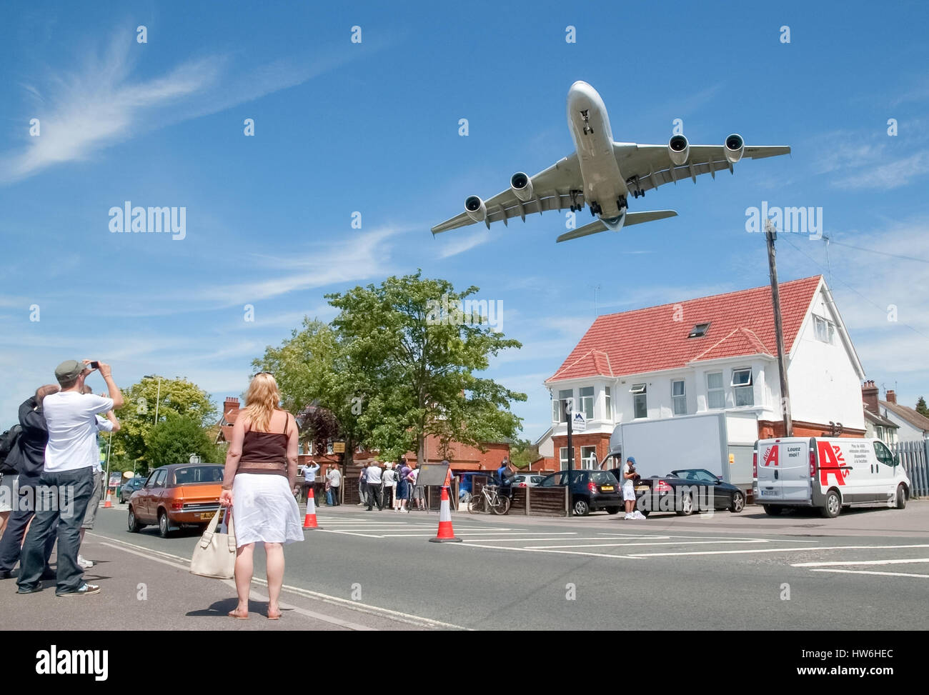 Massive Airbus A380 aircraft on landing approach over local suburban street and arriving at the Farnborough Airshow, Stock Photo