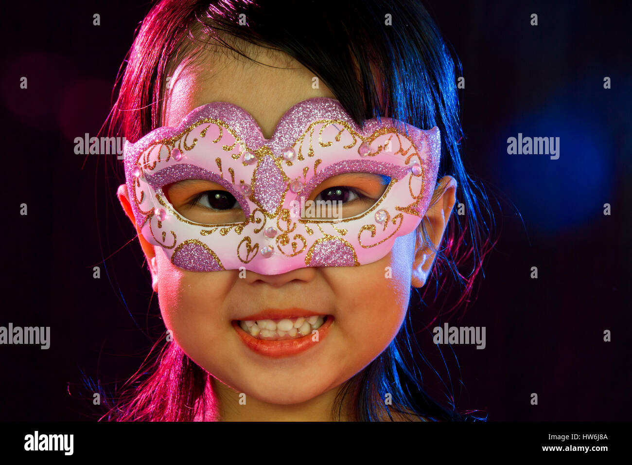 Asian Little Chinese Girl Wearing Mask isolated on Black Bakground Stock Photo