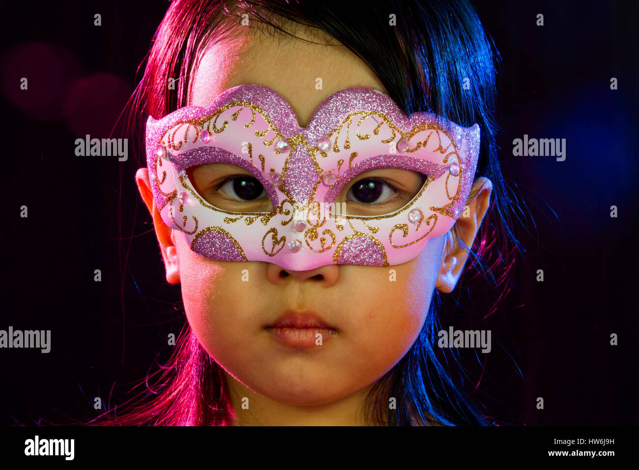 Asian Little Chinese Girl Wearing Mask isolated on Black Bakground Stock Photo