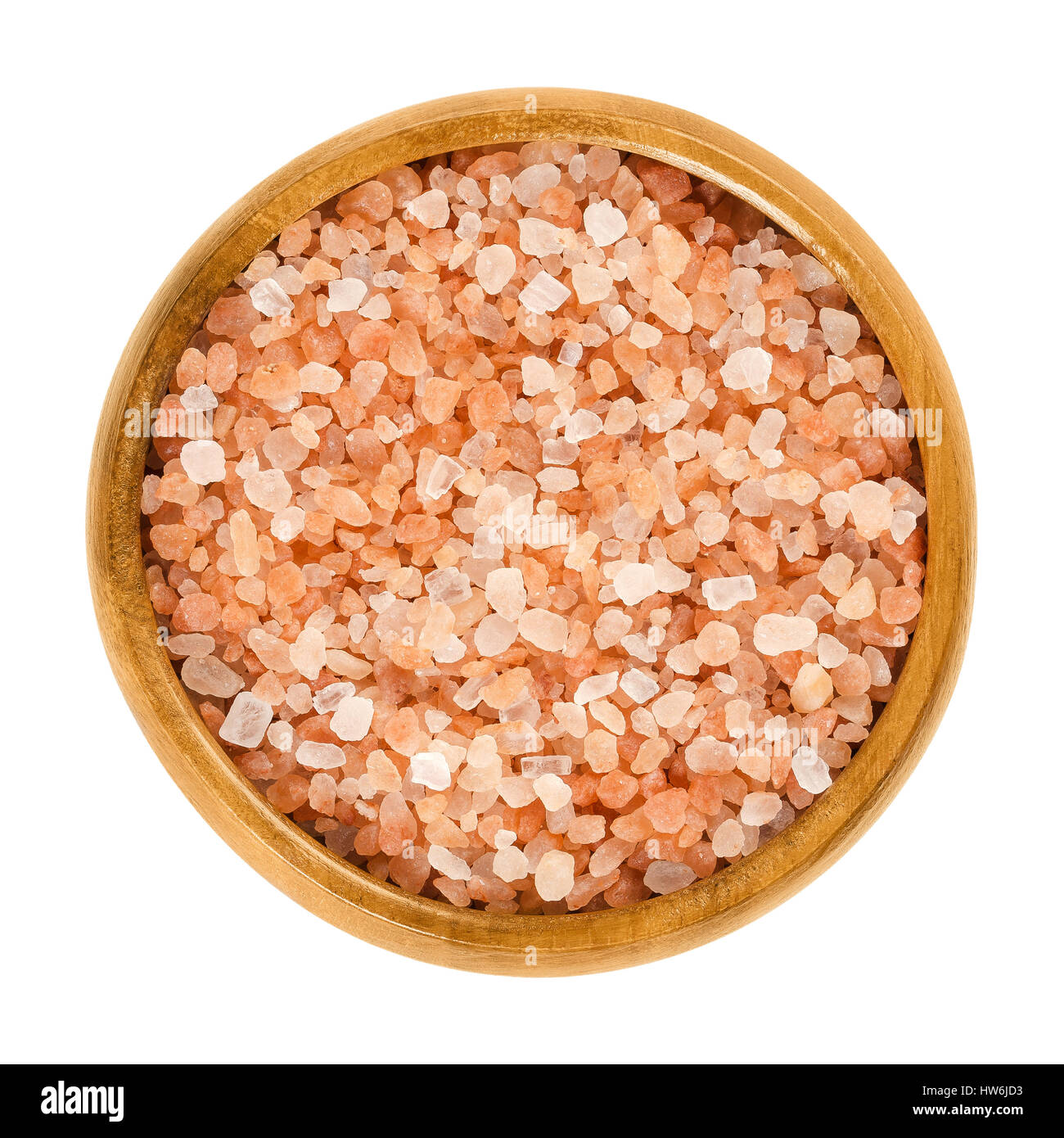 Himalayan salt in wooden bowl. Rock salt. Halite from Punjab region, Pakistan. Similar to table salt plus pink colored mineral impurities. Stock Photo