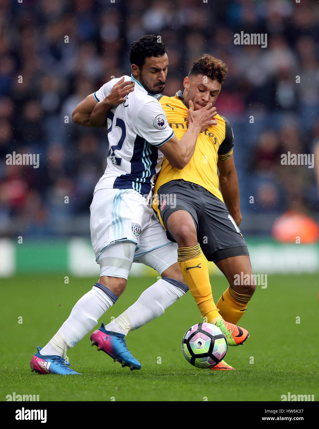 West Bromwich Albion's Nacer Chadli (left) and Arsenal's Alex Oxlade-Chamberlain battle for the ball during the Premier League match at The Hawthorns, West Bromwich. Stock Photo