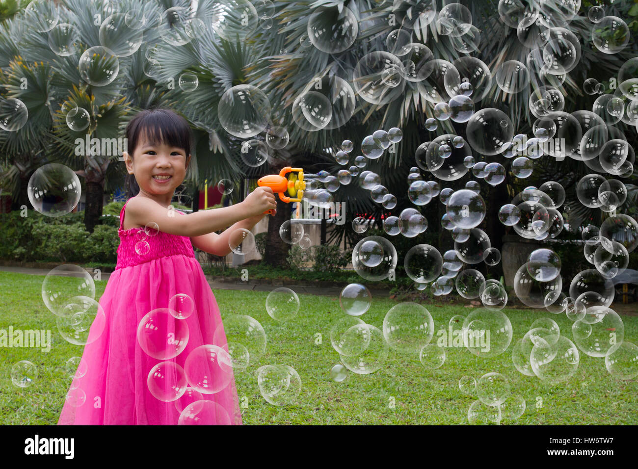 Asian Little Chinese Girls Shooting Bubbles from Bubble Blower in the