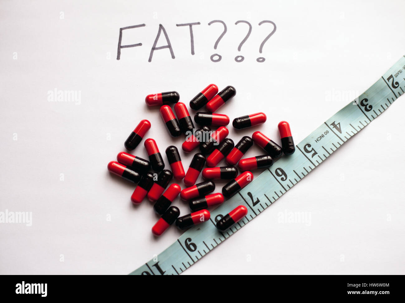 Weight loss concept with fat burner pills and measuring tape Stock Photo