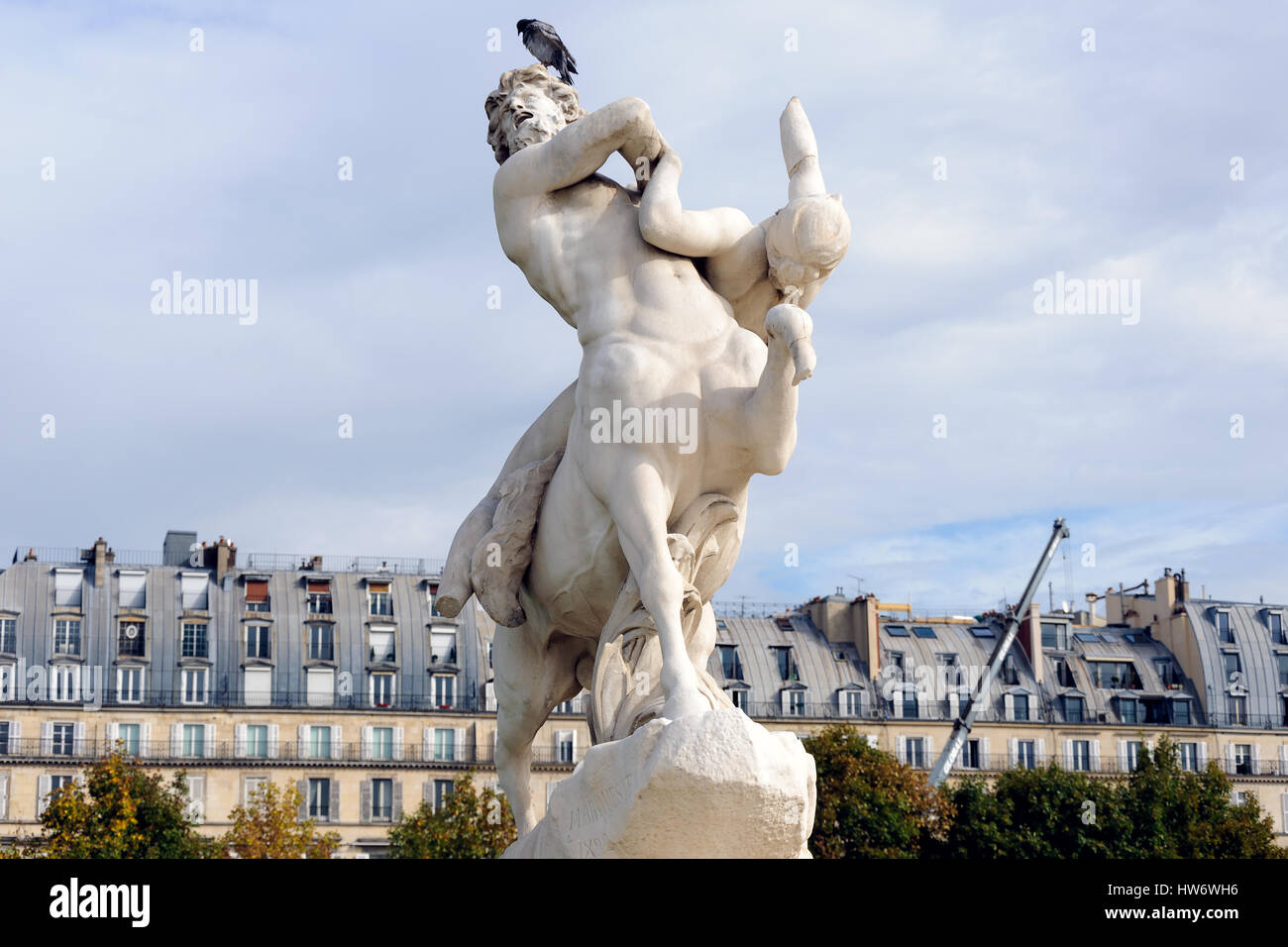 Beautiful classical statue and pigeon on the head in Tuileries Garden