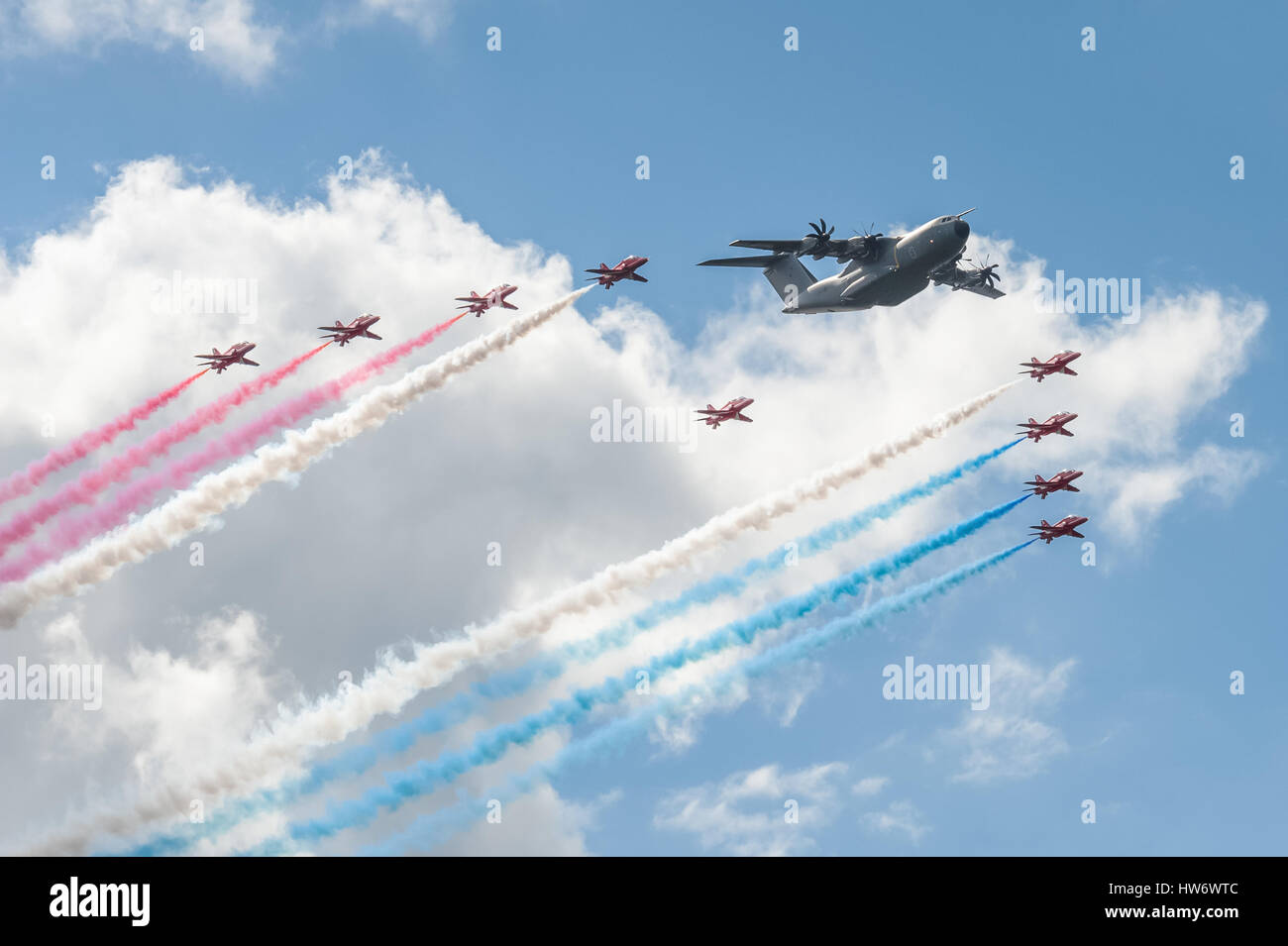 Red Arrows formation flying team and an Airbus A400 transporter in the skies over Farnborough, UK Stock Photo