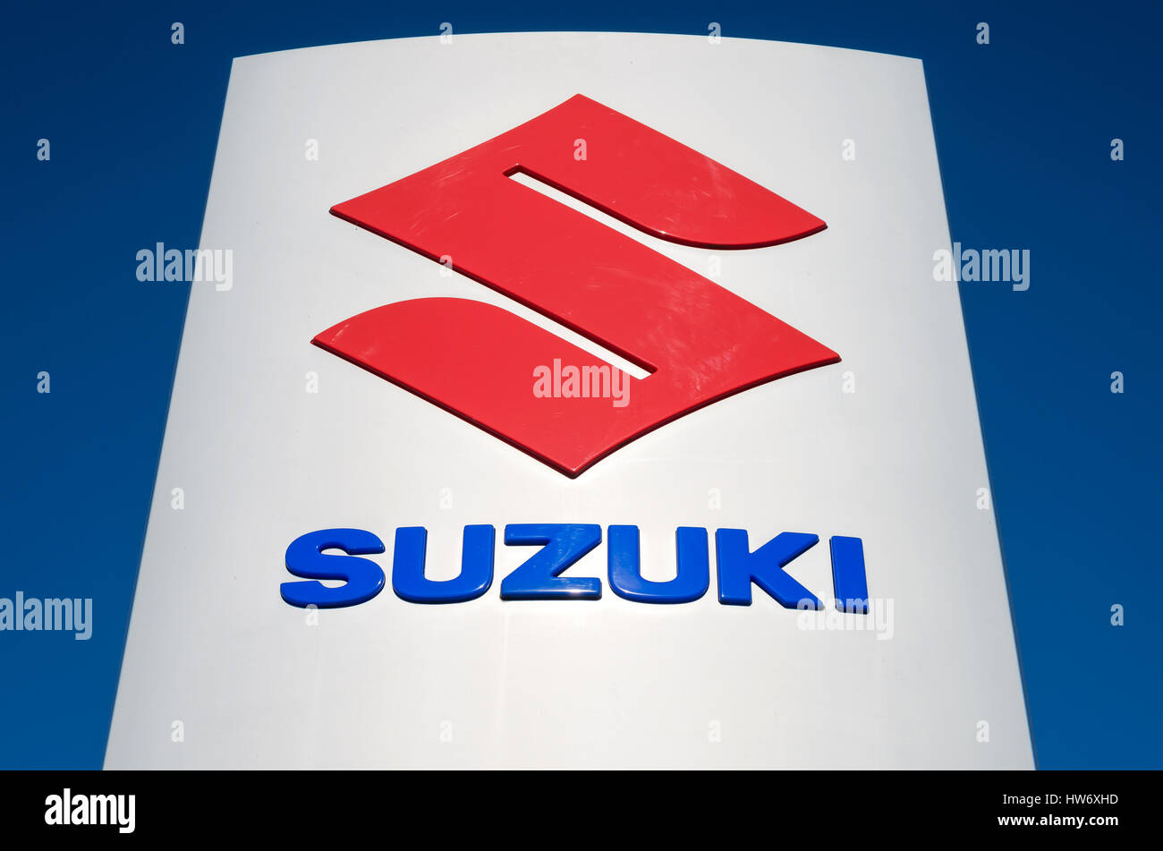 https://c8.alamy.com/comp/HW6XHD/suzuki-dealership-sign-against-blue-sky-HW6XHD.jpg