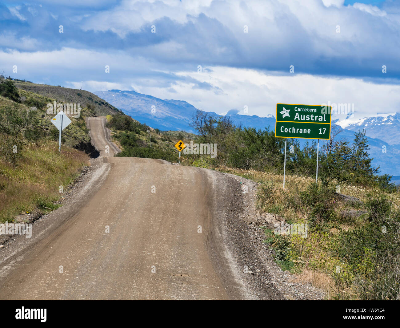 Carretera Austral north of Cochrane, gravel surface, signpost showing distance to Cochrane, mountain range in background, Patagonia, Chile Stock Photo