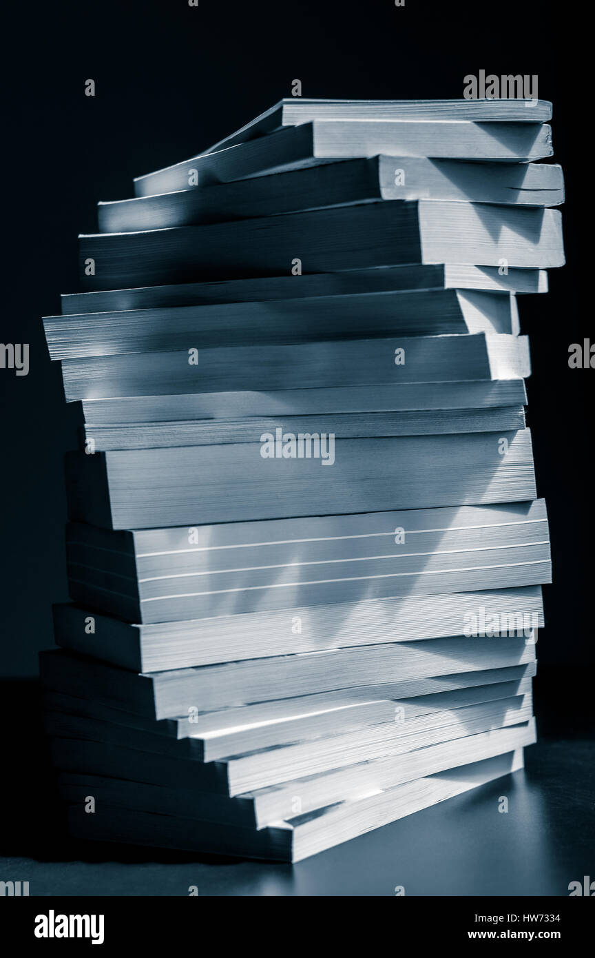 swirl of stacked books in black and white blue toned closeup Stock ...