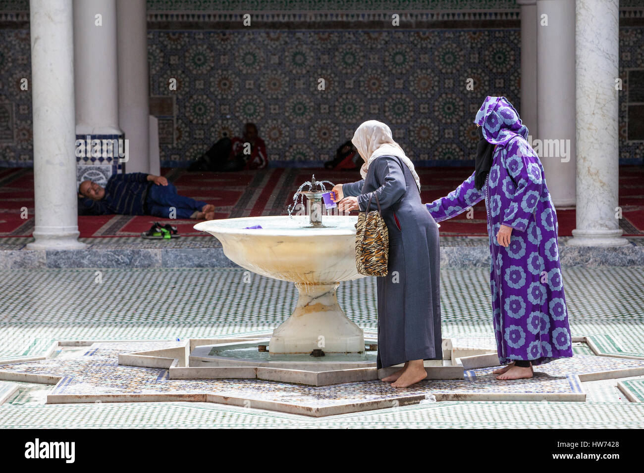 Fes, Morocco.  Women Getting Water for Ablutions, Mausoleum of Moulay Idris II, Fes El-Bali. Stock Photo
