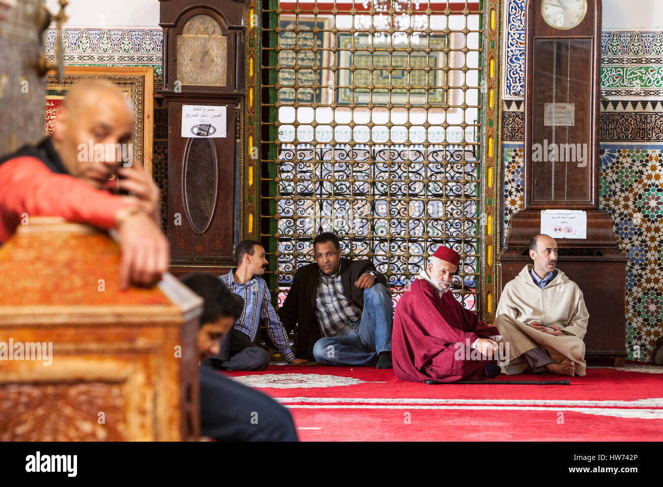 Fes, Morocco.  Men Resting inside the Mausoleum of Moulay Idris II, in the Medina, Fes El-Bali. Stock Photo