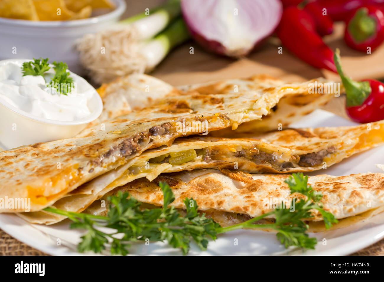 Southwest beef quesadila served with fresh chilli peppers and sourcream. Stock Photo