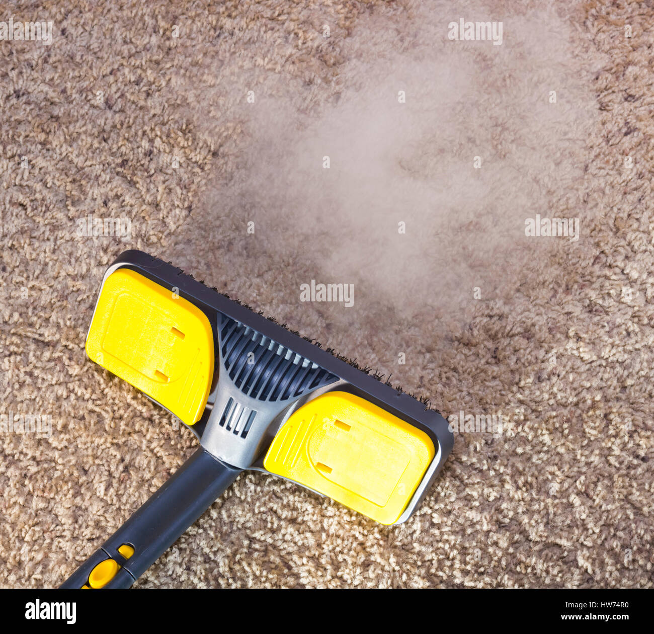 Using dry steam cleaner to sanitize floor carpet. Stock Photo