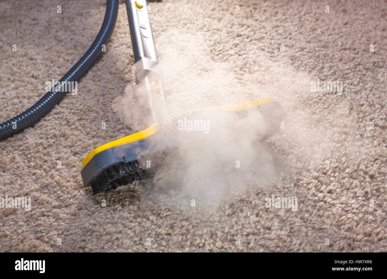 Using dry steam cleaner to sanitize floor carpet. Stock Photo