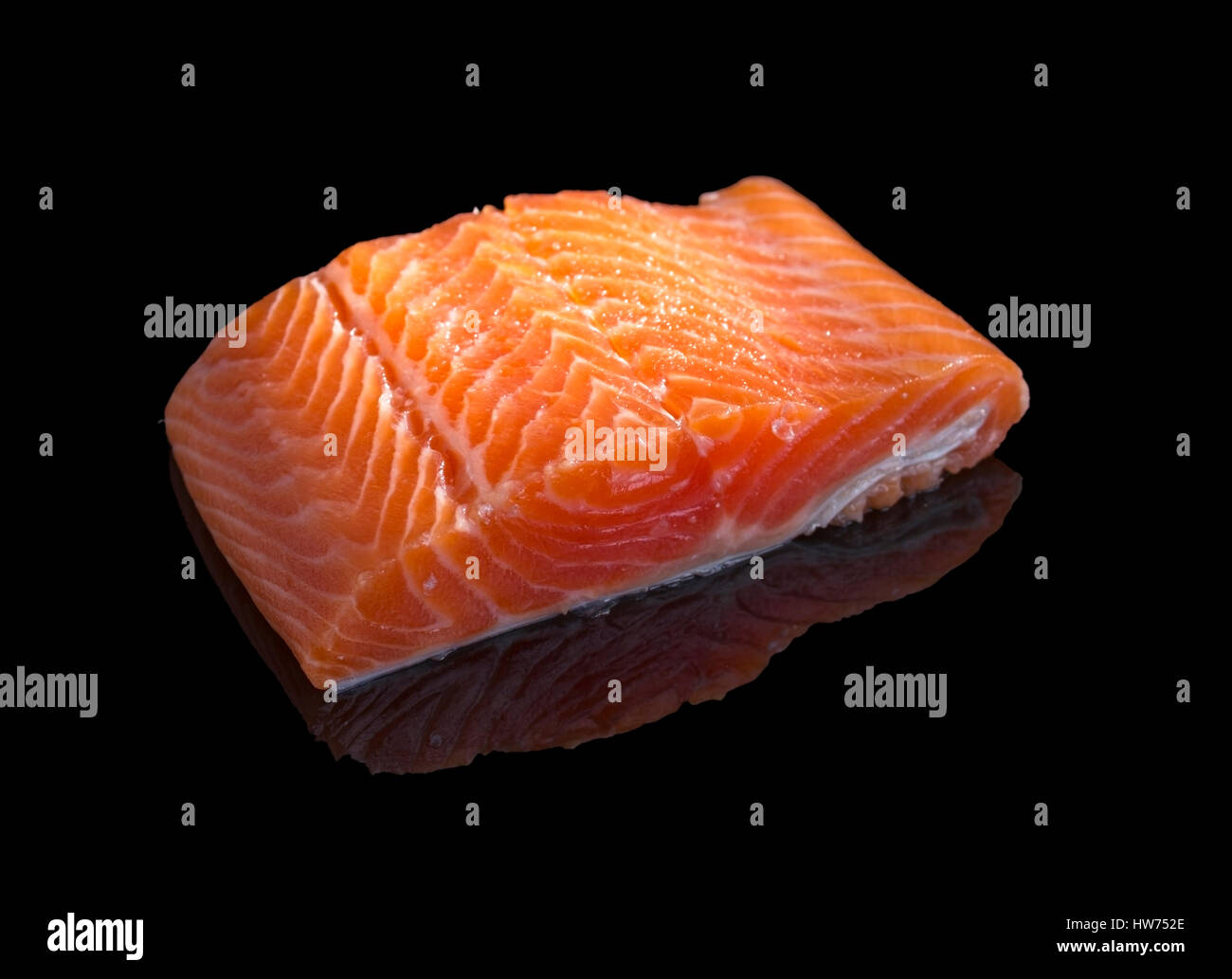 Raw salmon steak isolated on black background with reflection. Stock Photo
