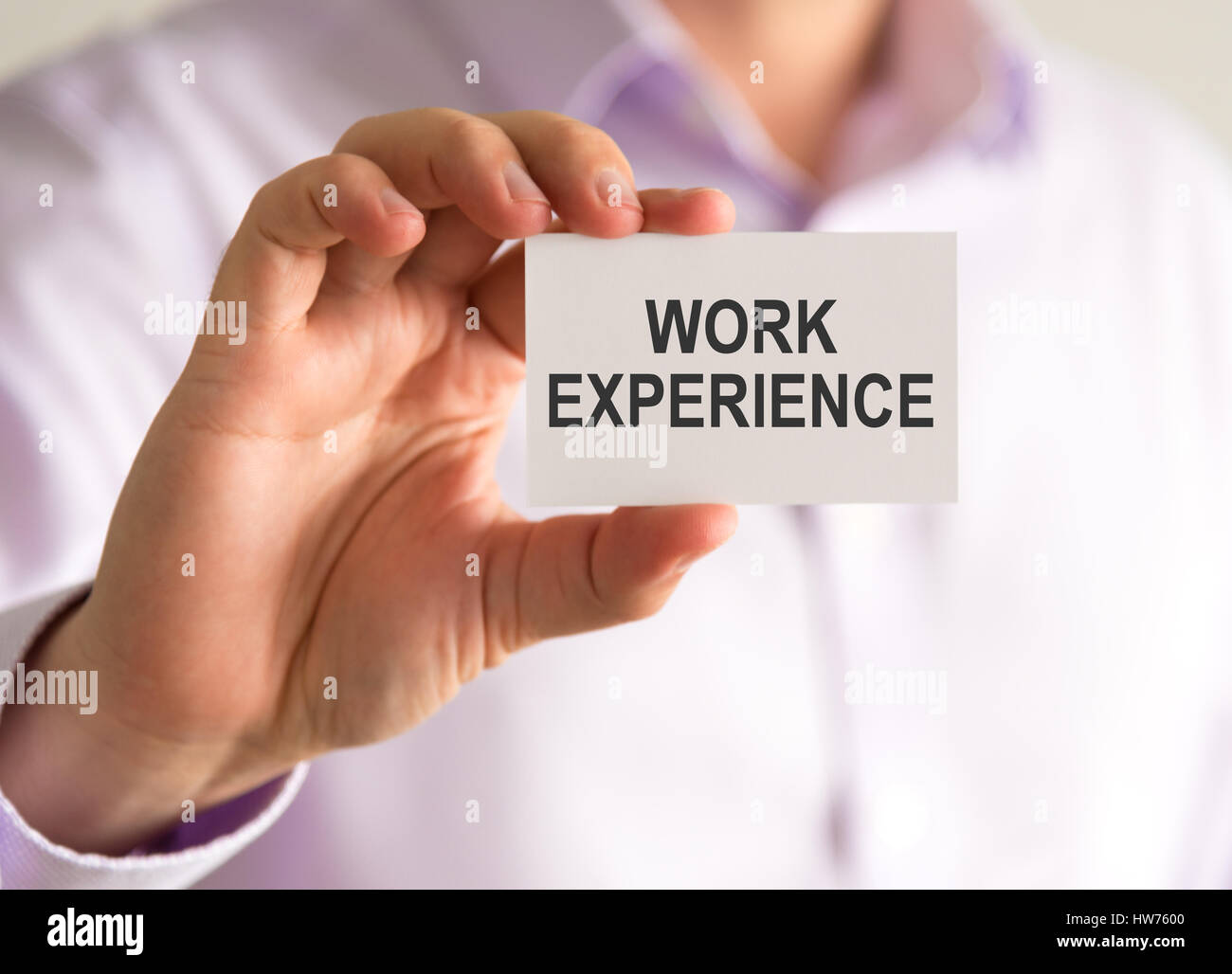 Closeup on businessman holding a card with WORK EXPERIENCE message, business concept image with soft focus background Stock Photo