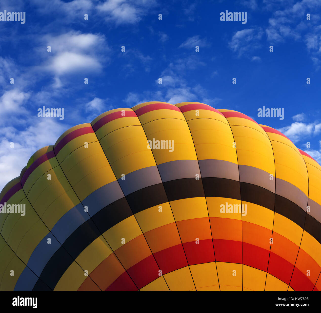 Hot air balloon on blue sky with clouds at nice sunny day. Close-up view. Stock Photo