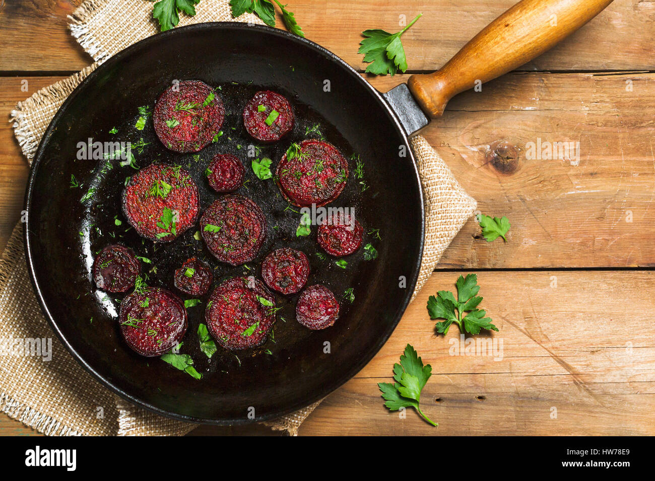 Fried beet slices on a cast-iron frying pan. Top view. Flat lay Stock Photo