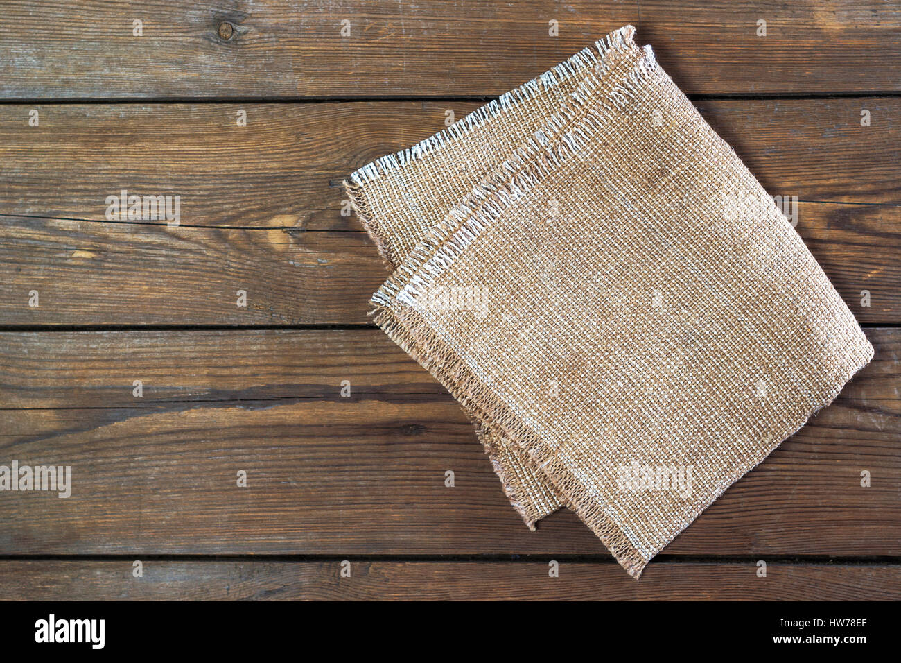 Linen napkin on vintage wooden kitchen table. Top view. Flat lay. Stock Photo