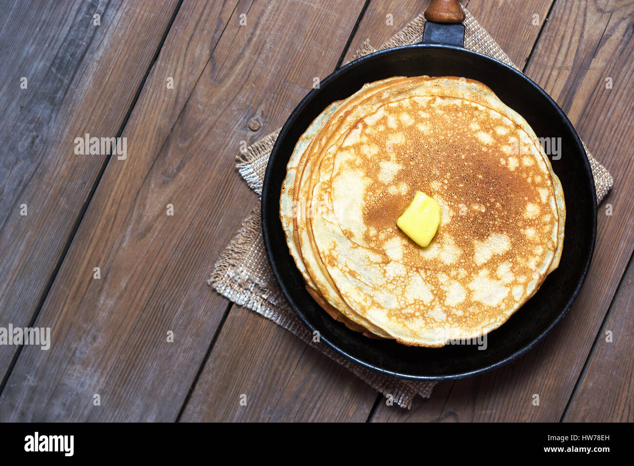 Stack of pancakes on a cast-iron frying pan with butter. Top view. Flat lay Stock Photo