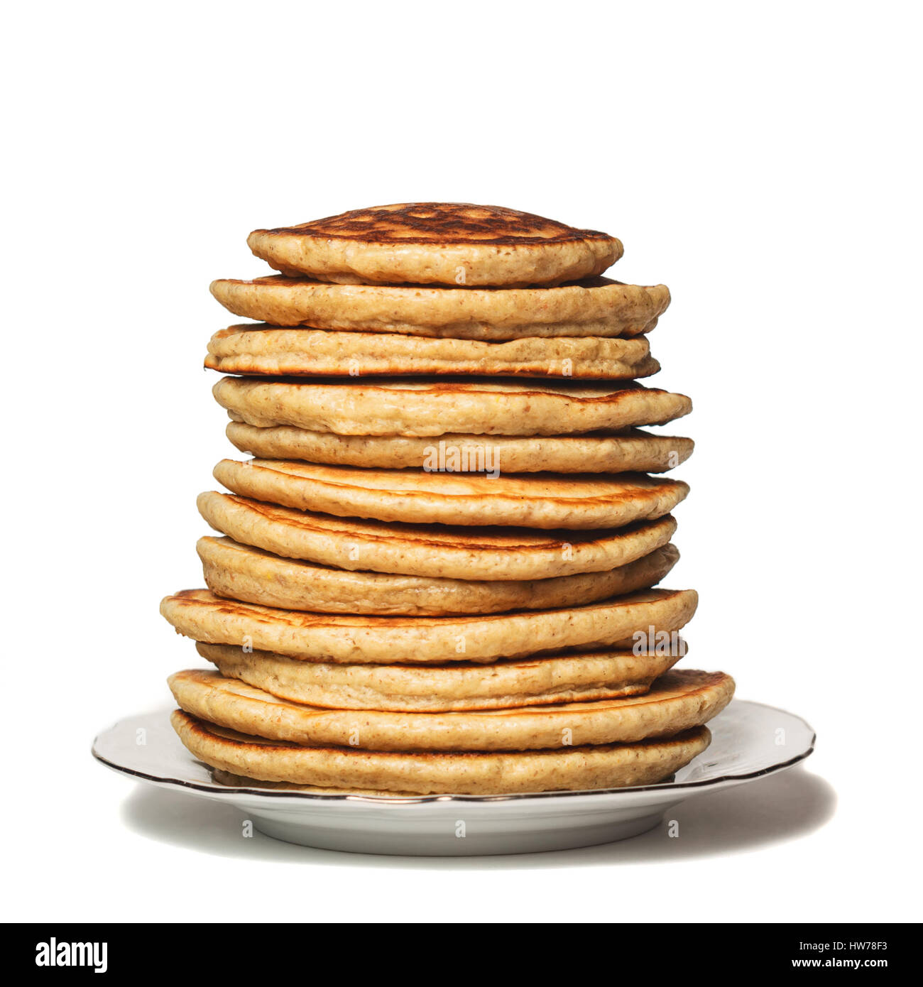 High stack of Oat pancakes on a plate. Isolated on white. Shallow DOF Stock Photo