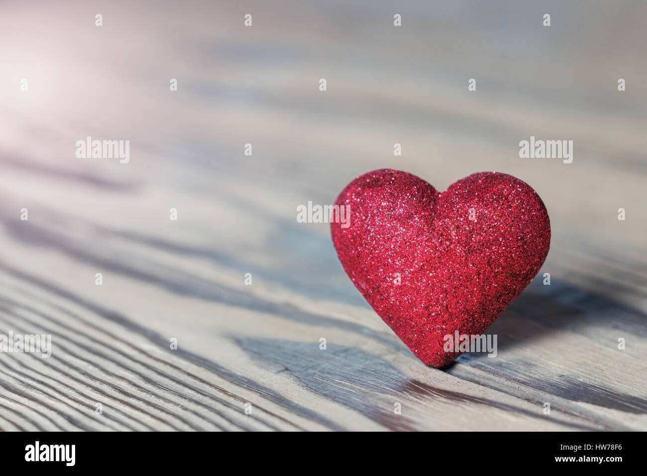 Red heart with glitter on wood. St. Valentine's Day. Shallow DOF, soft focus. With toning Stock Photo
