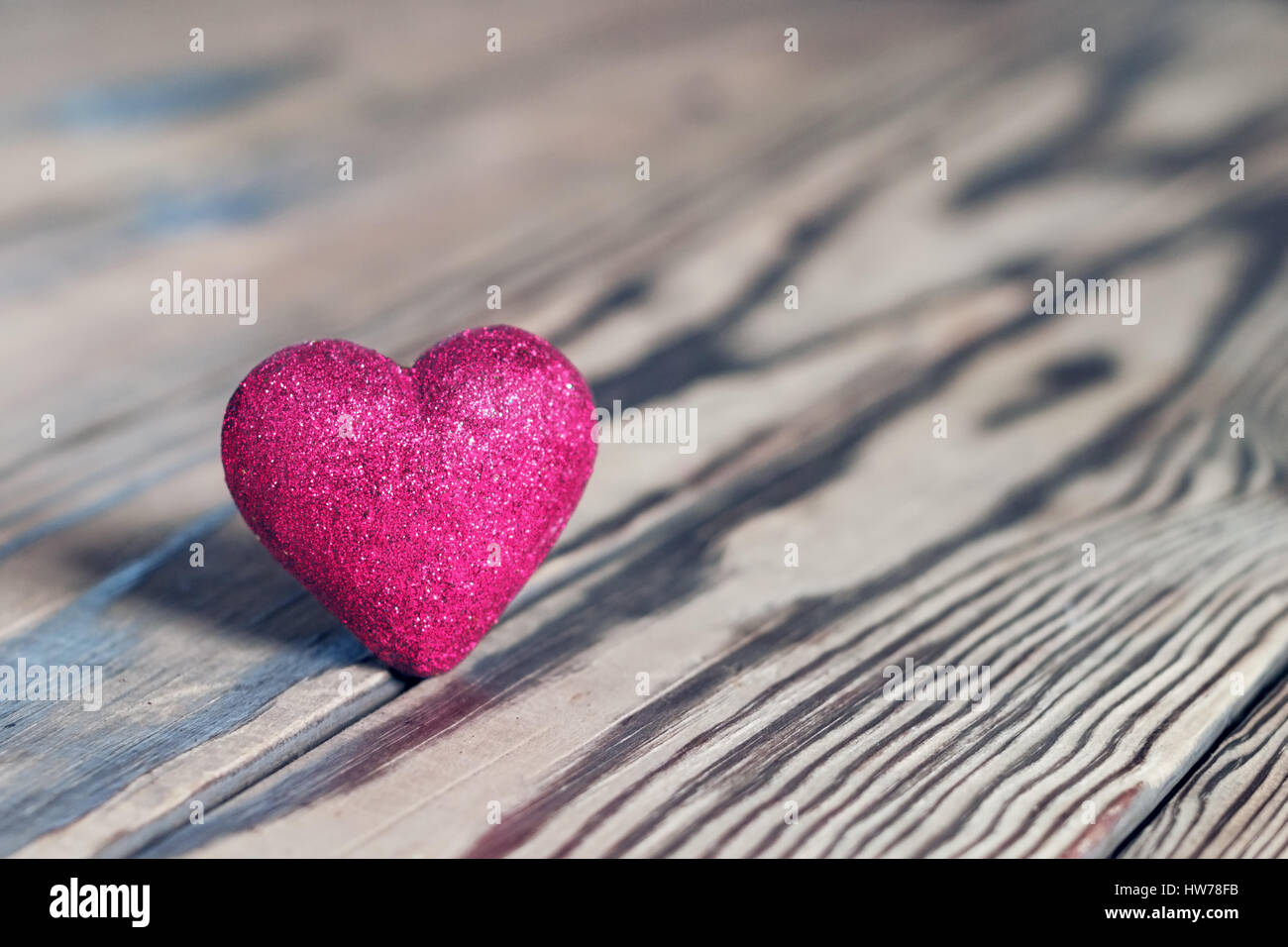 Red heart with glitter on wood. St. Valentine's Day. Shallow DOF, soft focus. Stock Photo