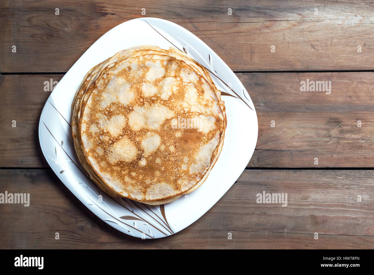 Stack of pancakes on a square plate on a wooden table. Top view. Flat lay Stock Photo