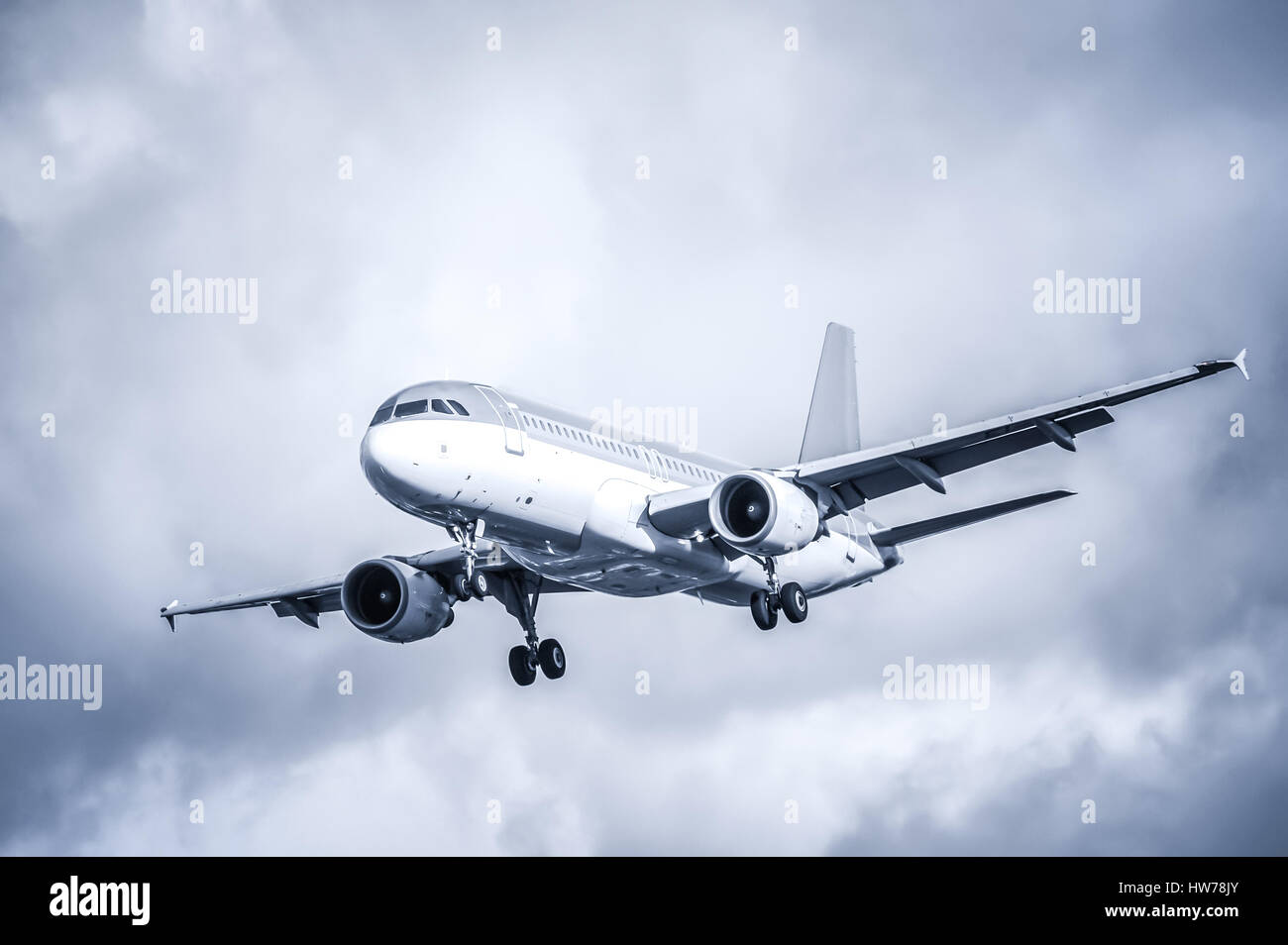 cool toned passenger aircraft landing in turbulence Stock Photo