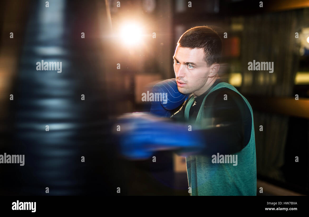 Young athlete boxer training with a punching bag Stock Photo