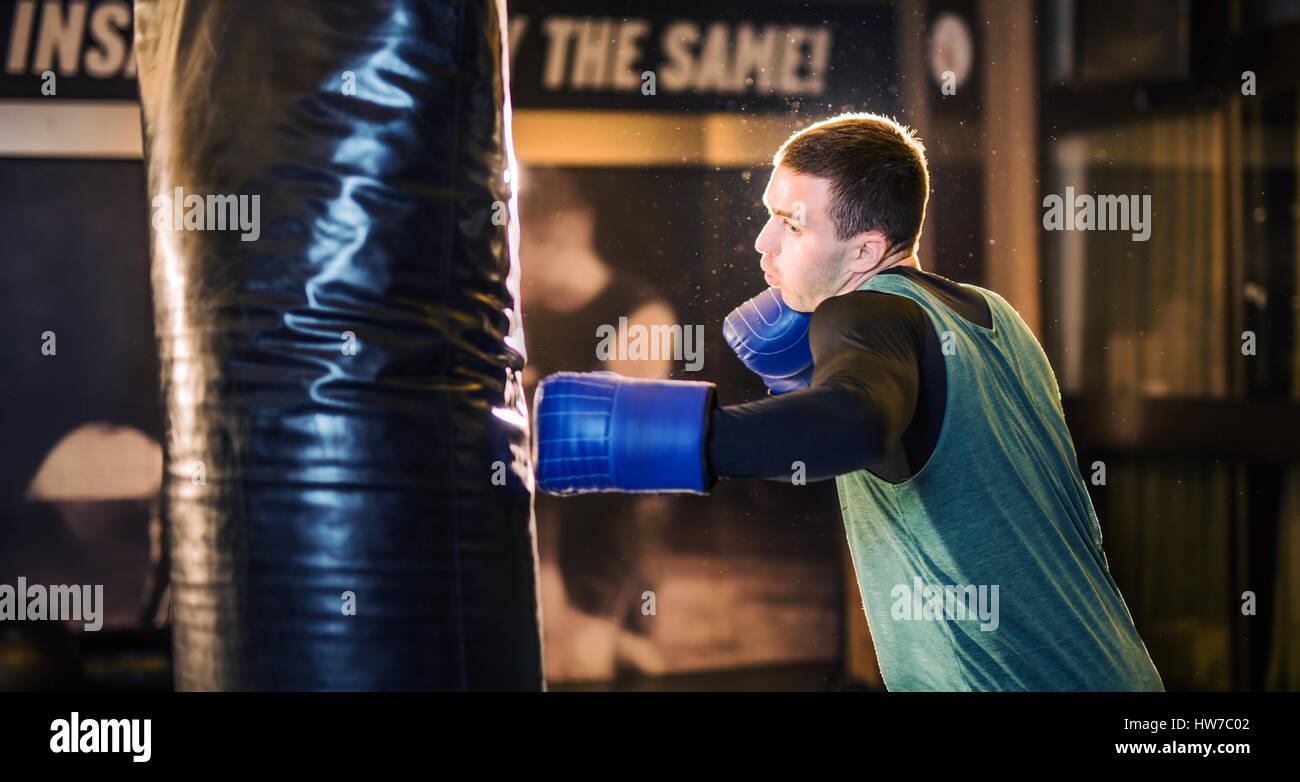 Young athlete boxer training with a punching bag Stock Photo
